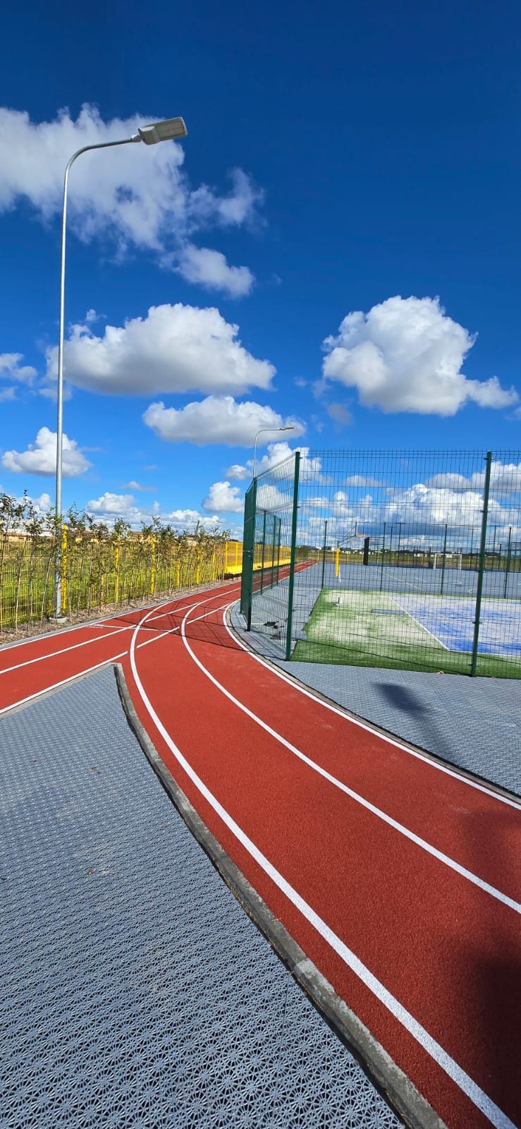 Aptverta sporto aikštyno teritorija su bėgimo taku